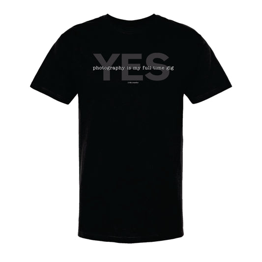 Black unisex t-shirt with the text 'YES, photography is my full time gig' printed on the front.
